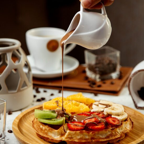 Healthy breakfast bowl with oats, berries, banana slices, and honey on a wooden table.