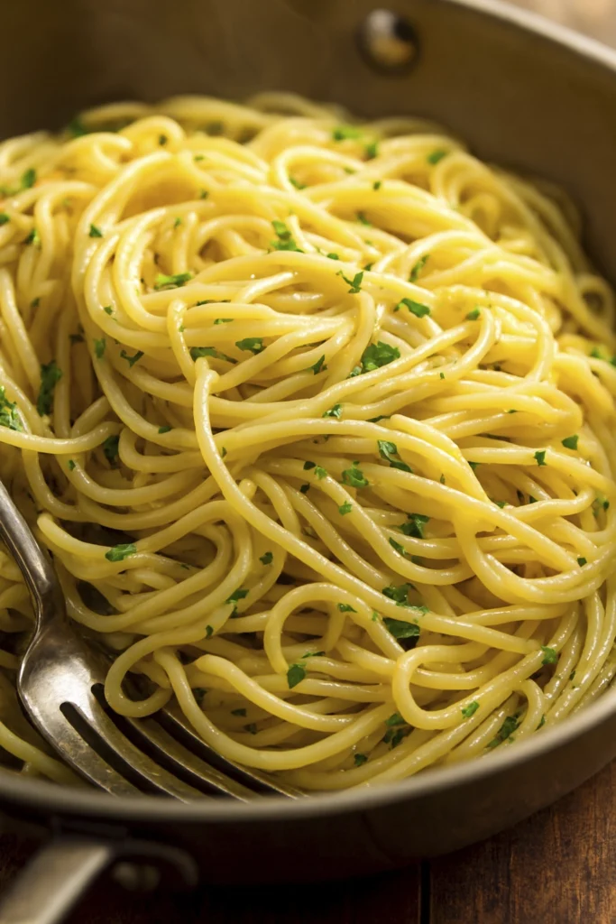 Minimalist gourmet spaghetti with olive oil and parsley in a metal pan.