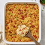Top-down view of golden chicken casserole with bacon, green onions, and creamy cheese interior.