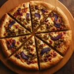 Rustic homemade pizza with sausage, red onions, and melted cheese on a wooden board in warm lighting