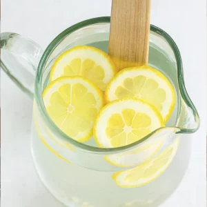 Top view of lemon water recipe with floating lemon slices