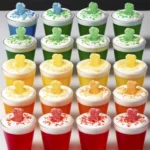 Sour Patch Shots in colorful gelatin cups topped with whipped cream and sour candy.