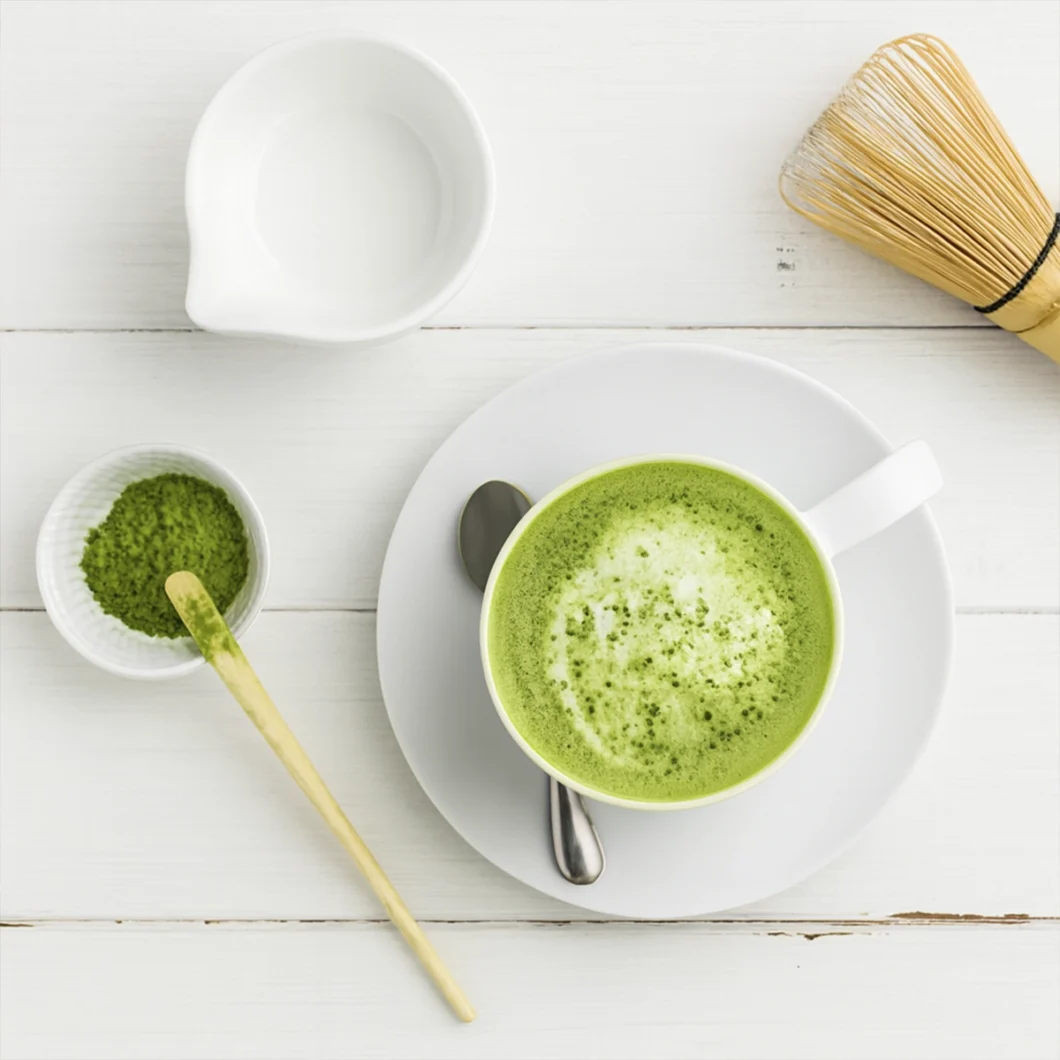Matcha green tea latte (hot or iced) being whisked with a bamboo chasen until frothy