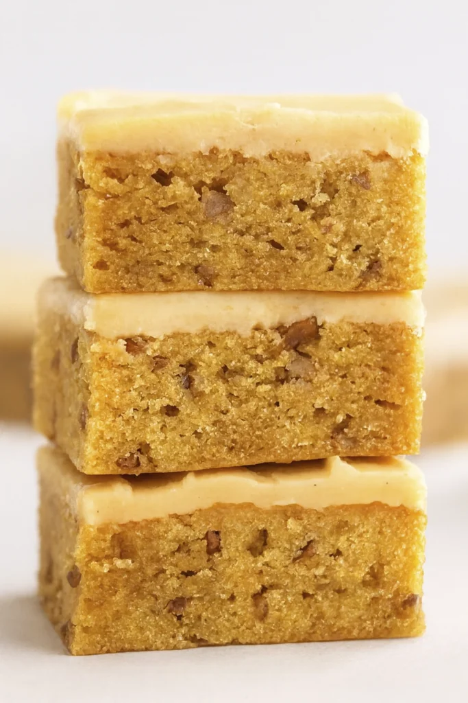 Apple pecan crumble bars with fresh apple slices and cinnamon sticks on a plate.