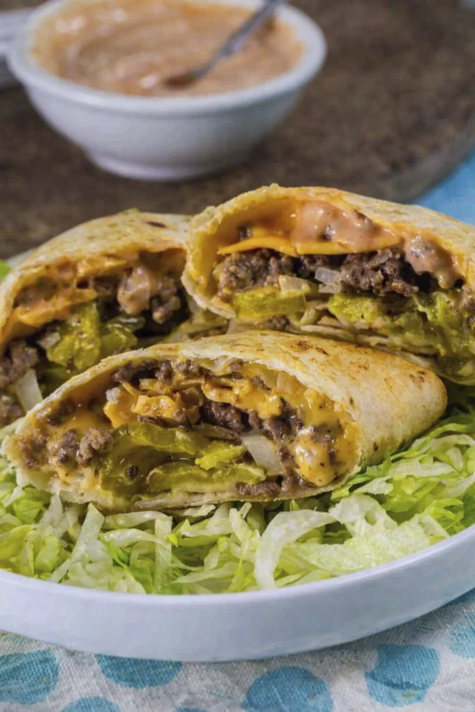 Close-up of cheeseburger wraps filled with beef, cheddar, pickles, onions, and creamy sauce