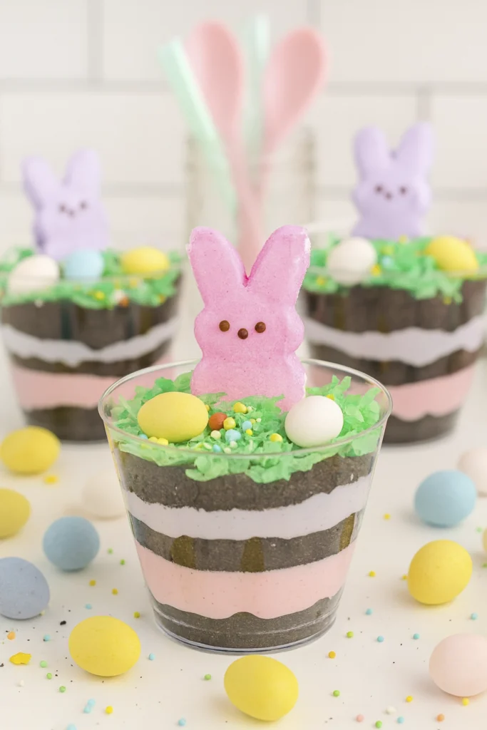 Easter Dirt Cups with pastel marshmallow bunnies, candy eggs, and coconut grass in clear cups, perfect for spring celebrations.