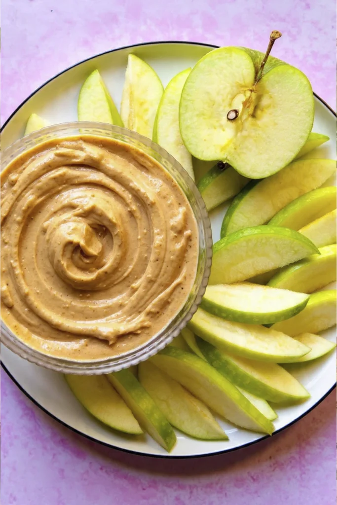 Greek Yogurt Apple Dip with fresh green apple slices arranged around a creamy peanut butter bowl